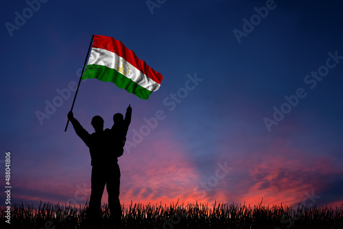 Father and son hold the flag of Tajikistan