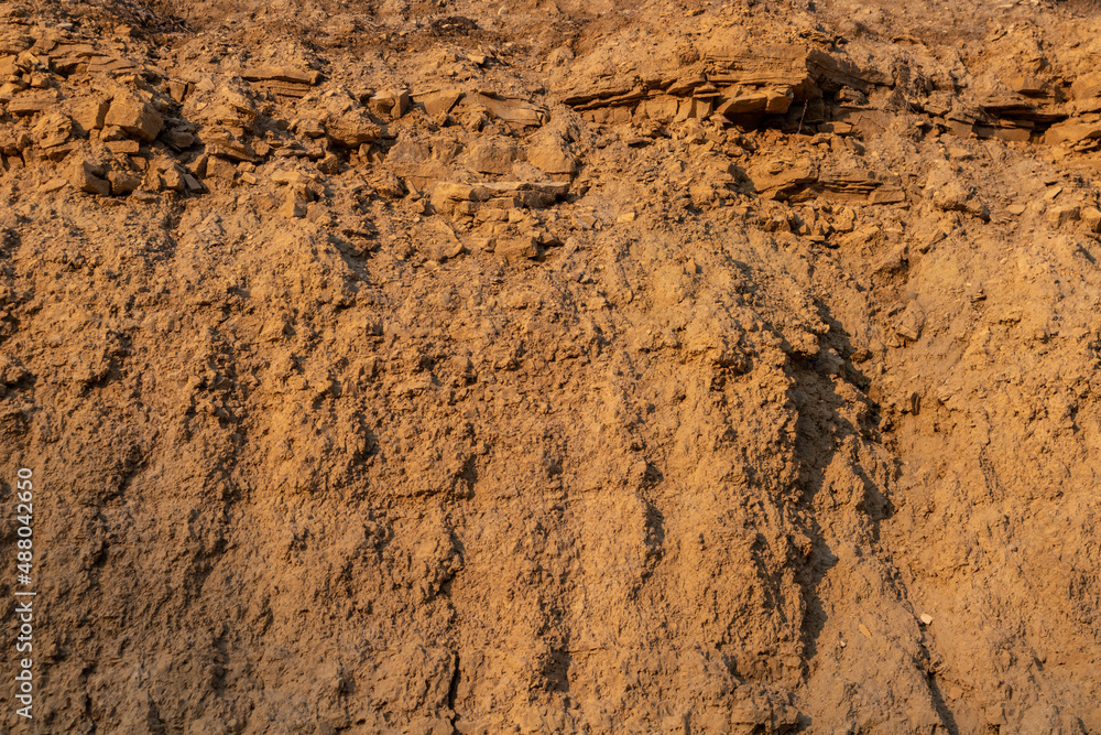 Limestone and clay cliff surface of yellow-orange color.  Background texture.