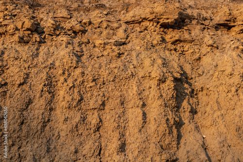Limestone and clay cliff surface of yellow-orange color. Background texture.