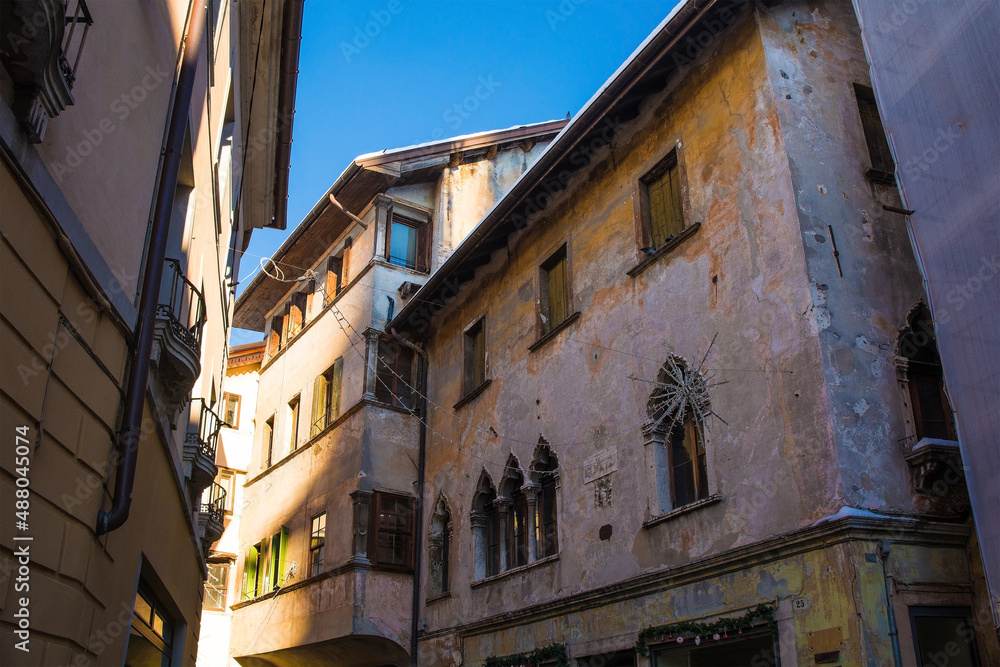 Historic buildings with Christmas decorations in the north east Italian city of Belluno, Veneto region. The building on the right has double lancet windows on the first floor
