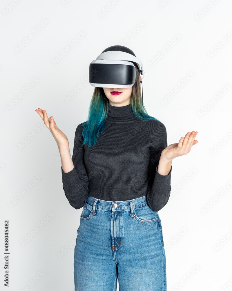 Teen girl using vr headset is in virtual reality cyberspace vhite background, vertical frame. The concept of the metaverse, virtual reality, virtual social universe. Future digital technologies.