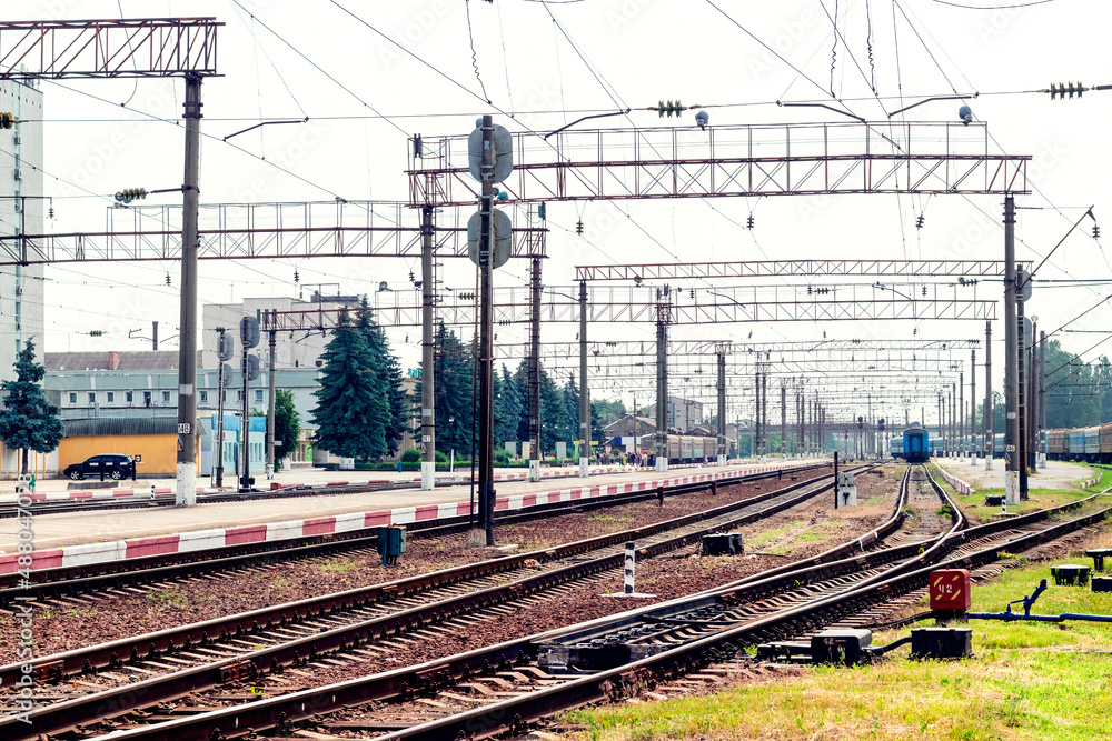Railway station with rails, buildings and trains in the distance Railway station with rails, buildings and trains in the distance
