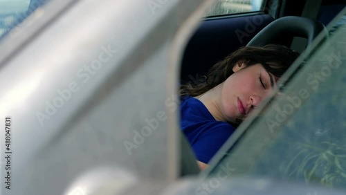 Girl wakes up at dawn in the car with a hangover photo