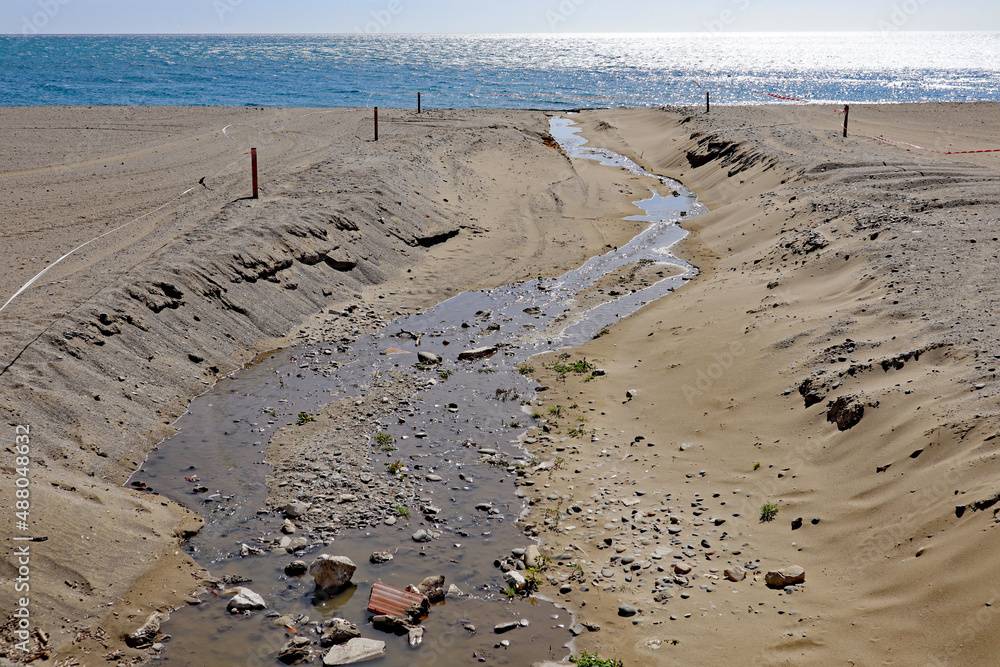 A stream flows across the beach in Estepona in Spain. It is taped off to prevent people going into the water. A stream flows across the beach in Estepona in Spain. It is taped off to prevent people going into the water.