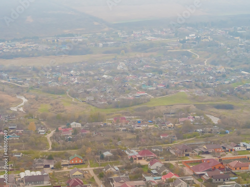 View of the village with small houses from the window of the plane. Soft focus