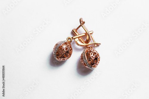 earrings of gold color with a large stone on a white background