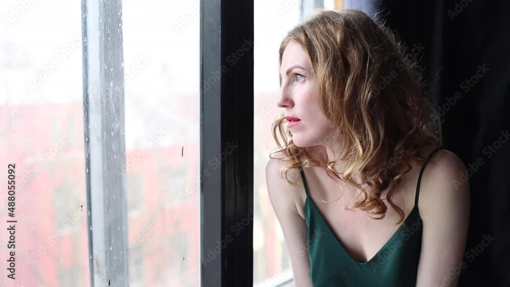 Portrait of woman looking through the window at home. people and hope concept - close up of happy white woman Portrait of woman looking through the window at home. people and hope concept - close up of happy white woman