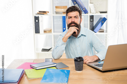 Serious manager thinking sitting at office desk at workplace