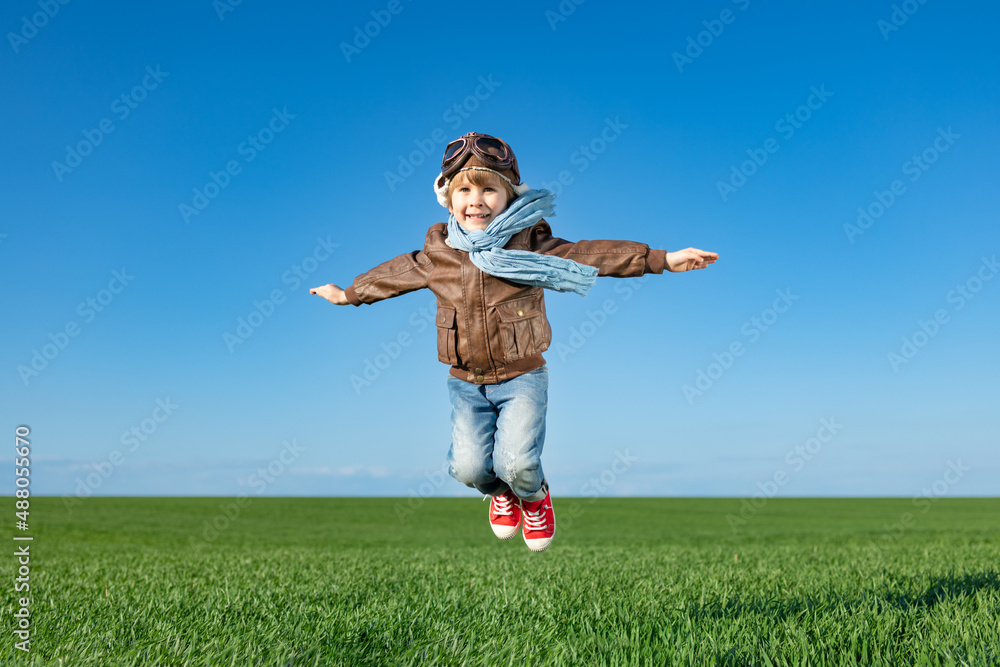 Happy child jumping outdoor in spring field Happy child jumping outdoor in spring field