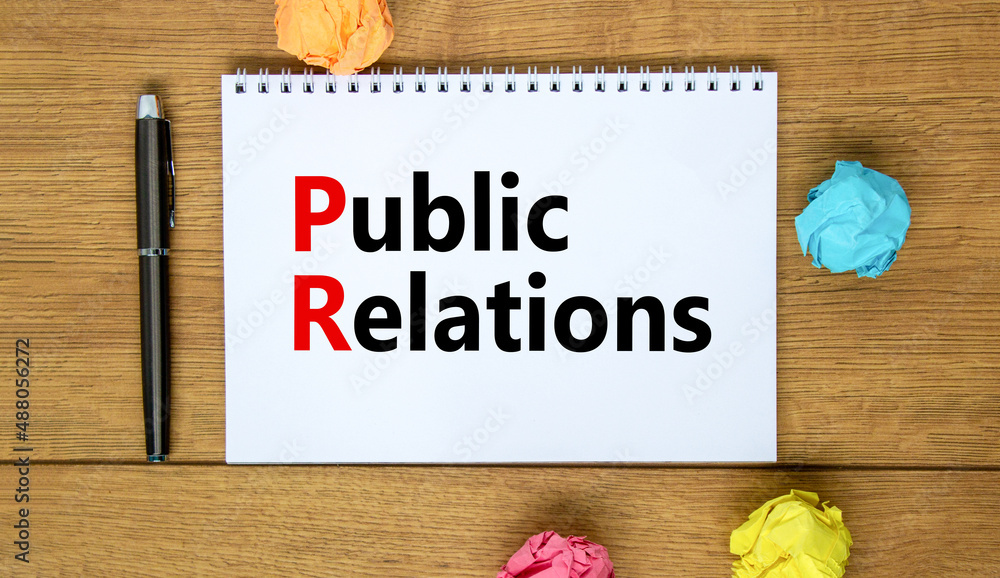 Fototapeta premium PR public relations symbol. Concept words PR public relations on white note. Metallic pen. Beautiful wooden background. Copy space. Business and PR public relations concept.