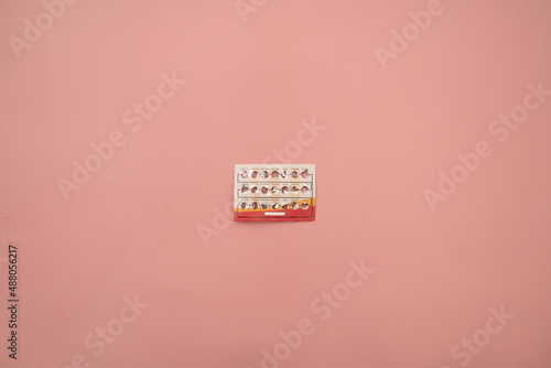 Female oral contraceptive pills blister on pink background. Women contraceptive hormonal birth control pills. Planning pregnancy concept. Copy space, flat lay. photo
