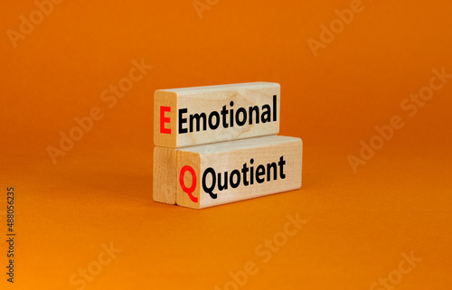 EQ emotional quotient symbol. Concept words EQ emotional quotient on wooden blocks on a beautiful orange table orange background. Business EQ emotional quotient concept, copy space.