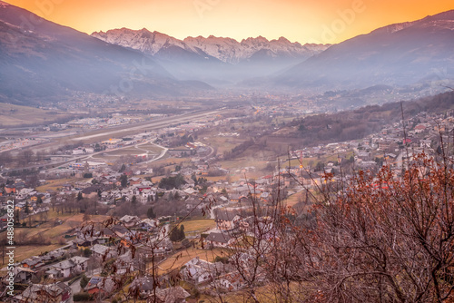 sunset over Aosta city with snow-capped mountains in the background and colorful sky