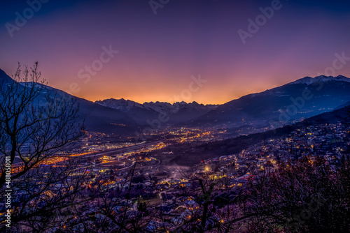sunset over Aosta city with snow-capped mountains in the background and colorful sky photo