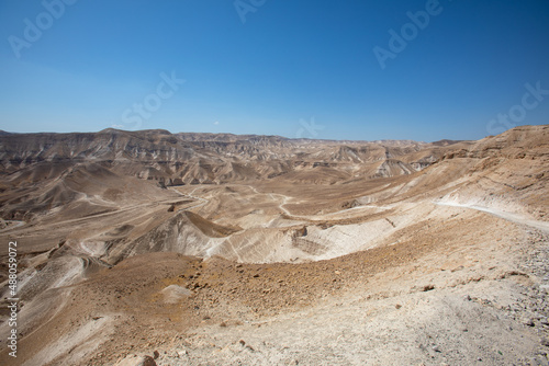 Beautiful landscape of Israeli Judean Desert mountains, with sunrise over the dry riverbed of Nahal Dragot Wadi, popular hiking trail winding between rugged rocky cliffs towards the Dead Sea. High photo