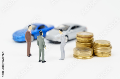 Car business, car sales, deal. On the white surface are cars, coins and miniature figurines of people