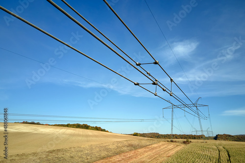 High voltage power line with insulation divider of electric power wires for safe delivering of electrical energy through steel cable on long distance photo