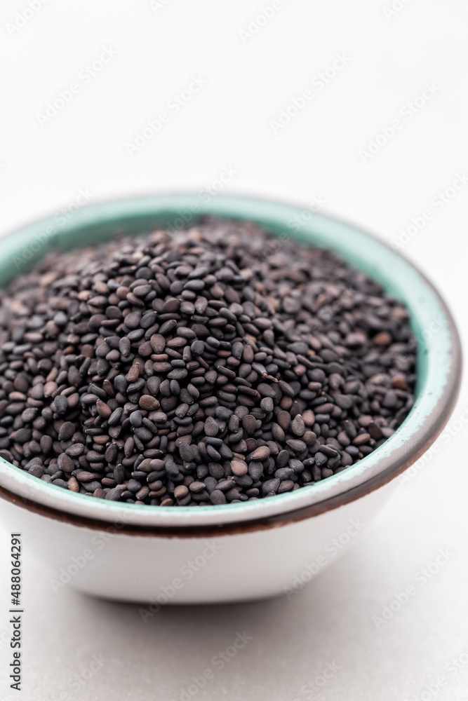 Bio natural black sesame seeds on white bowl. Bio natural black sesame seeds on white bowl.