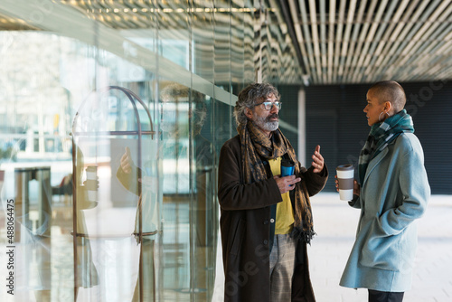 Wallpaper Mural Two business people talking and drinking coffee outside the office building during a break from work. Torontodigital.ca