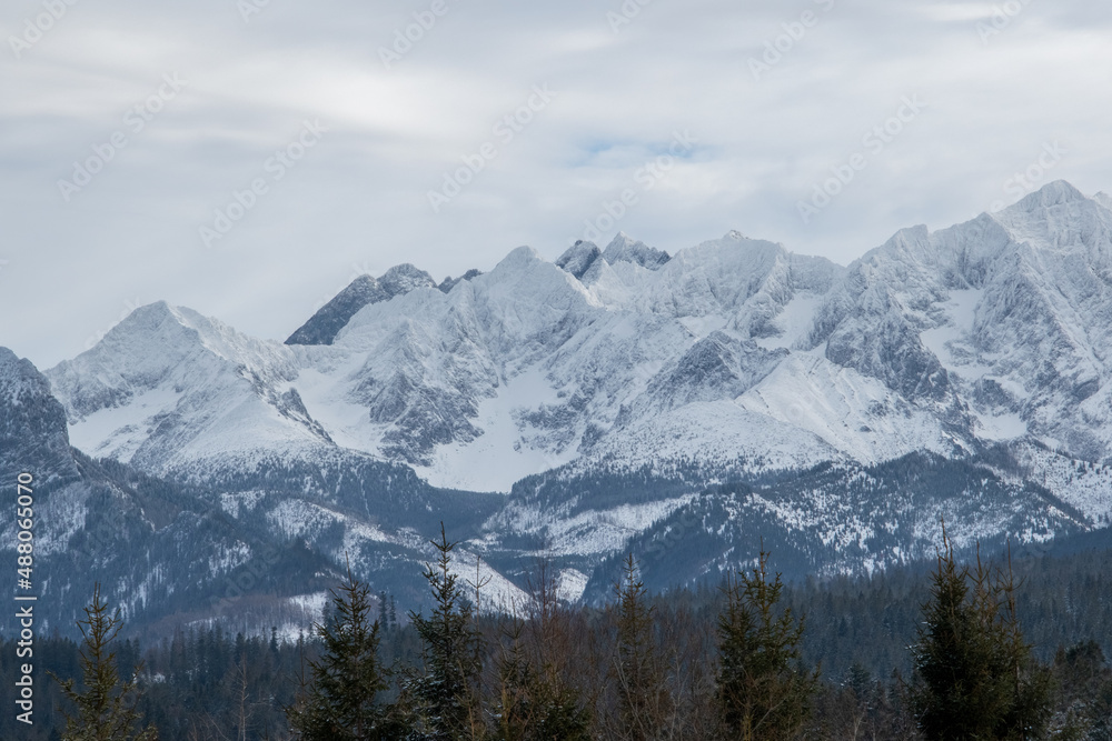 Beautiful view of the Polish Tatras in winter scenery. Mountain tops hidden in beautiful clouds.View on the highest peaks covered with snow in Polish Tatra Mountains.