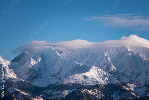 Beautiful view of the Polish Tatras in winter scenery.Mountain tops on the background of cloudless sky. View on the highest peaks covered with snow in Polish Tatra Mountains.