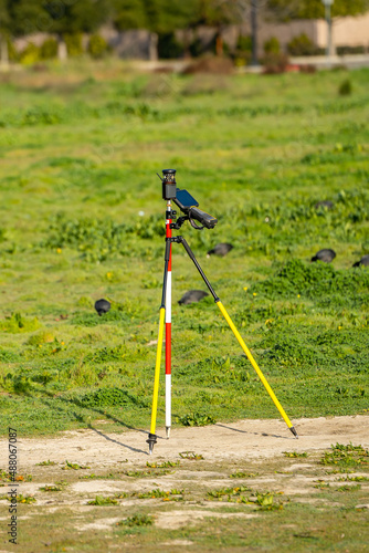 Geodetic measuring equipment stands on the field. Topographic survey of the area.