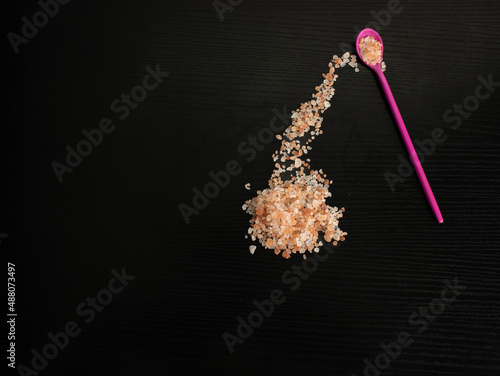 Himalayan pink salt, with fuchsia teaspoon and black background