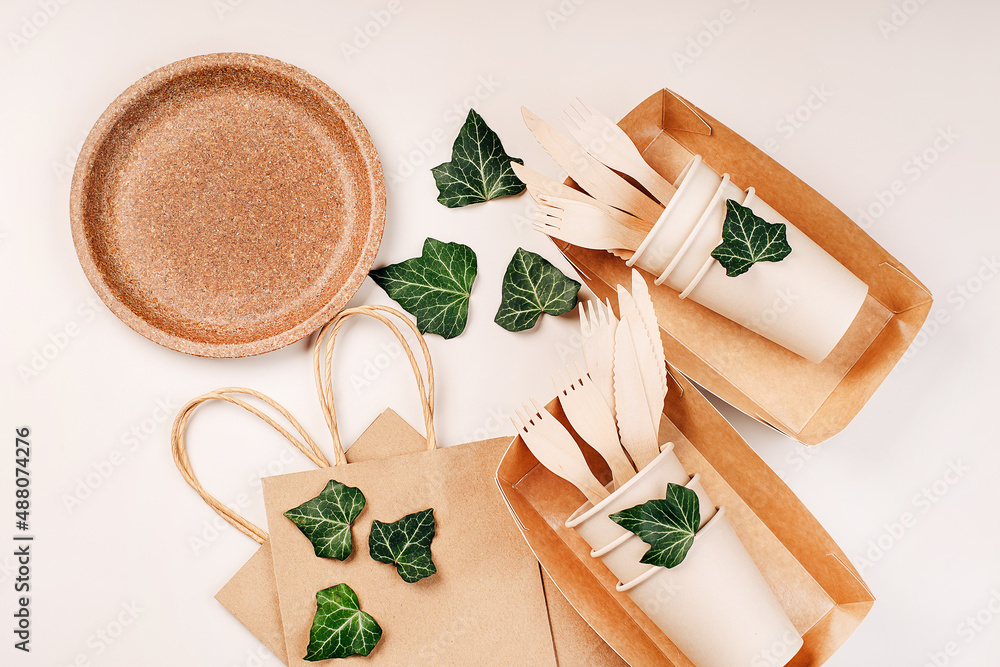 Eco craft paper tableware,cups,fast food containers.Recycling,eco-friendly concept.Disposable eco cutlery,plates,spoons,knives,forks on a light background.Craft paper bag for food delivery.Copy space. Eco craft paper tableware,cups,fast food containers.Recycling,eco-friendly concept.Disposable eco cutlery,plates,spoons,knives,forks on a light background.Craft paper bag for food delivery.Copy space.