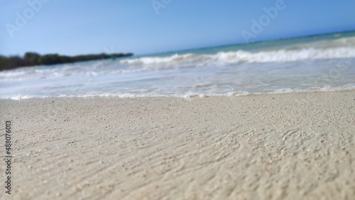 Beach sand closeup with waves on the background