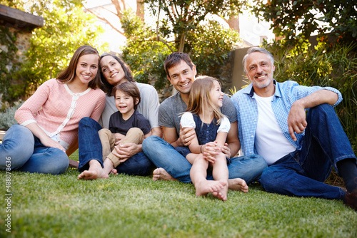 Together we have it all. A portrait of a multi-generational family sitting together in their garden.