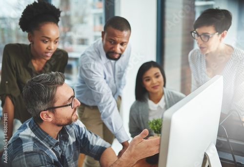 Working together to get the task done. Shot of businesspeople working together in the office.