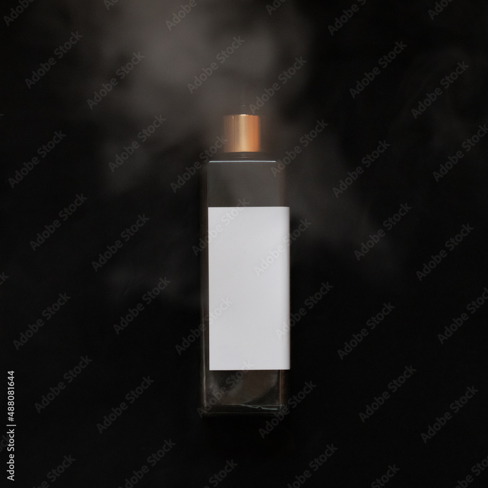 Black with gold cosmetic bottle on the black background. Water wapor. Mockup.