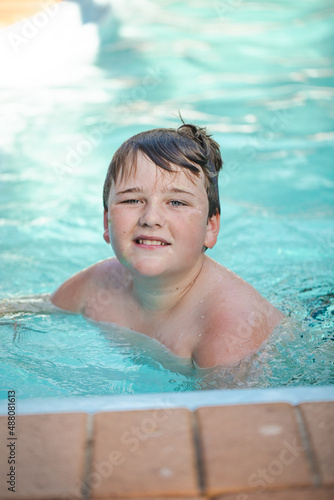 Happy pre-teen boy swimming in backyard pool © Caseyjadew
