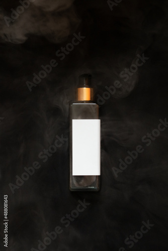 Obraz na płótnie Black with gold cosmetic bottle on the black background. Water wapor. Mockup. w salonie