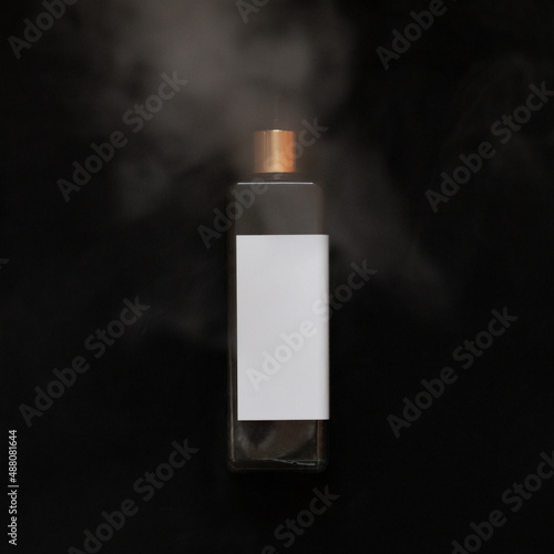 Obraz na płótnie Black with gold cosmetic bottle on the black background. Water wapor. Mockup. w salonie