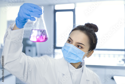 Female scientist looking at the scientific sample in the CDC laboratory.