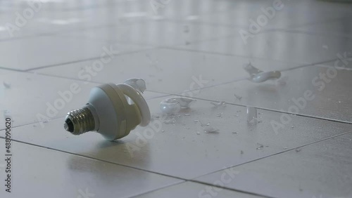 Slow motion shot of light bulb falling and crashig on floor
 photo