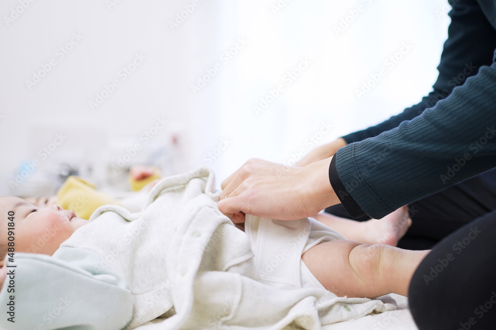 赤ちゃんのお着替えをするアジア人のお父さん 赤ちゃんのお着替えをするアジア人のお父さん