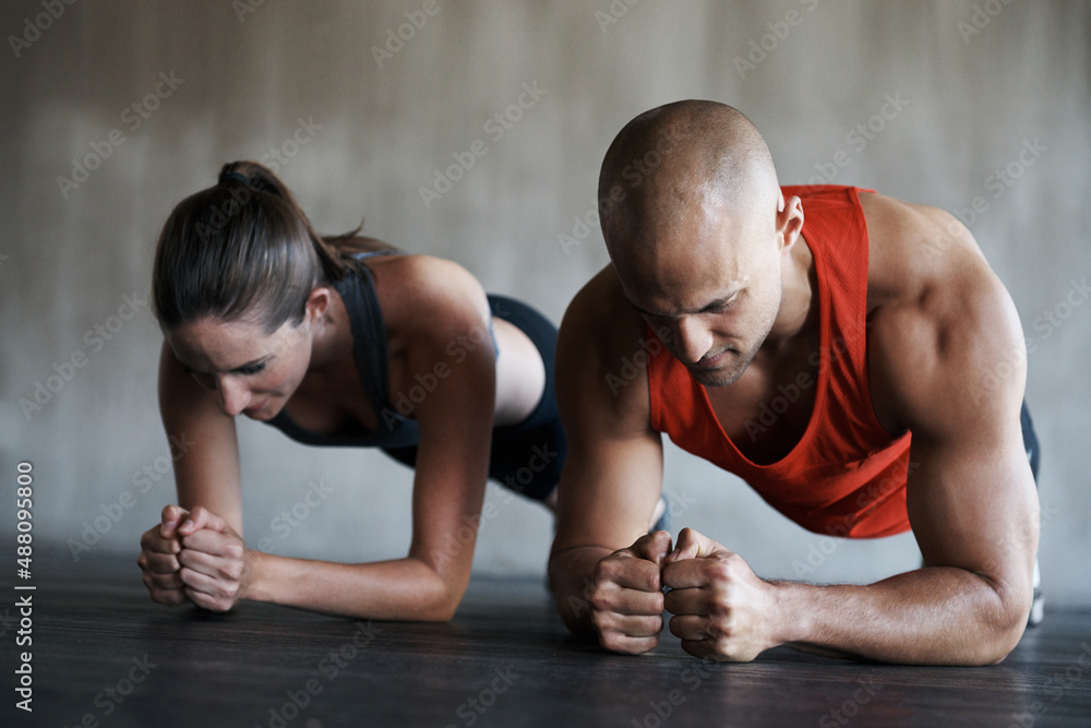 Push your way to fitness. Shot of a man and woman doing plank exercises at the gym. Push your way to fitness. Shot of a man and woman doing plank exercises at the gym.