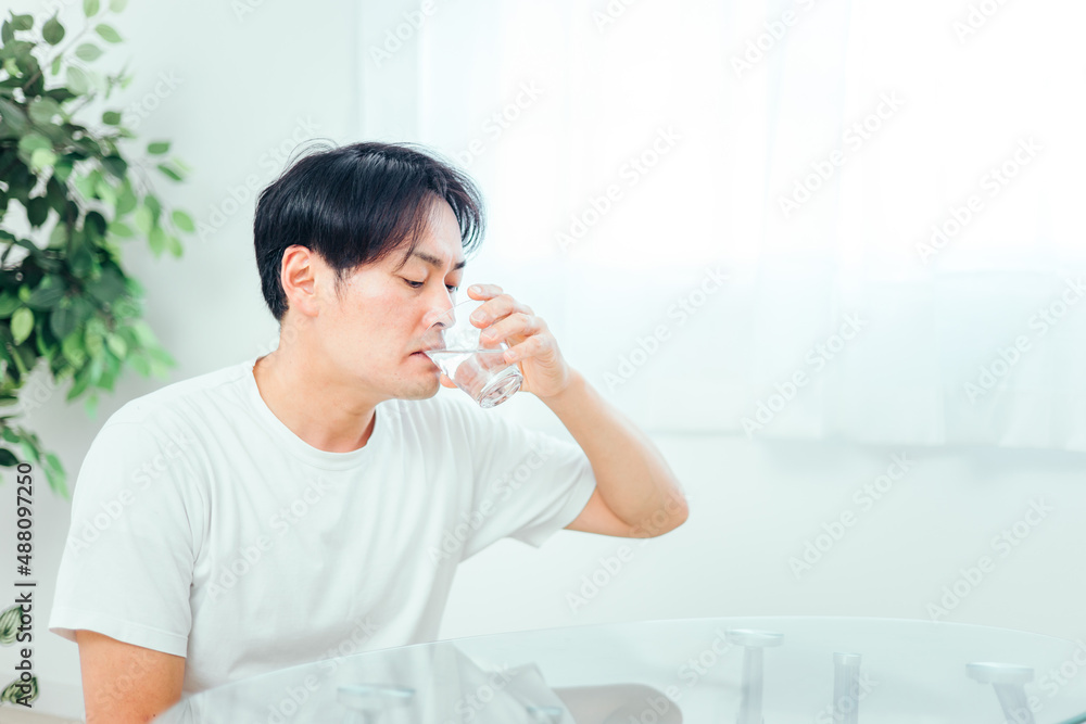 水・白湯を飲む男性
