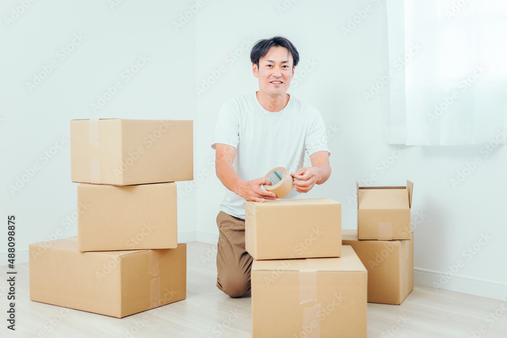 荷造りする男性(笑顔)
荷造りする男性(笑顔)