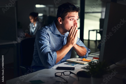 Being productive is about persevering. Cropped shot of a young attractive businessman working late in the office.