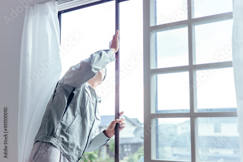 窓冊子を確認する作業着の男性
