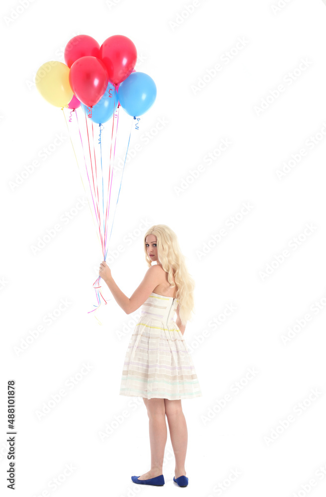 
Full length portrait of blonde girl wearing party dress, holding bunch of colourful balloons. Isolated on white studio background