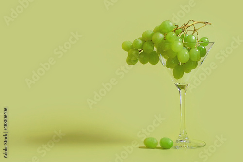 Billede på lærred A bunch of green grapes in a martini glass on a colored background