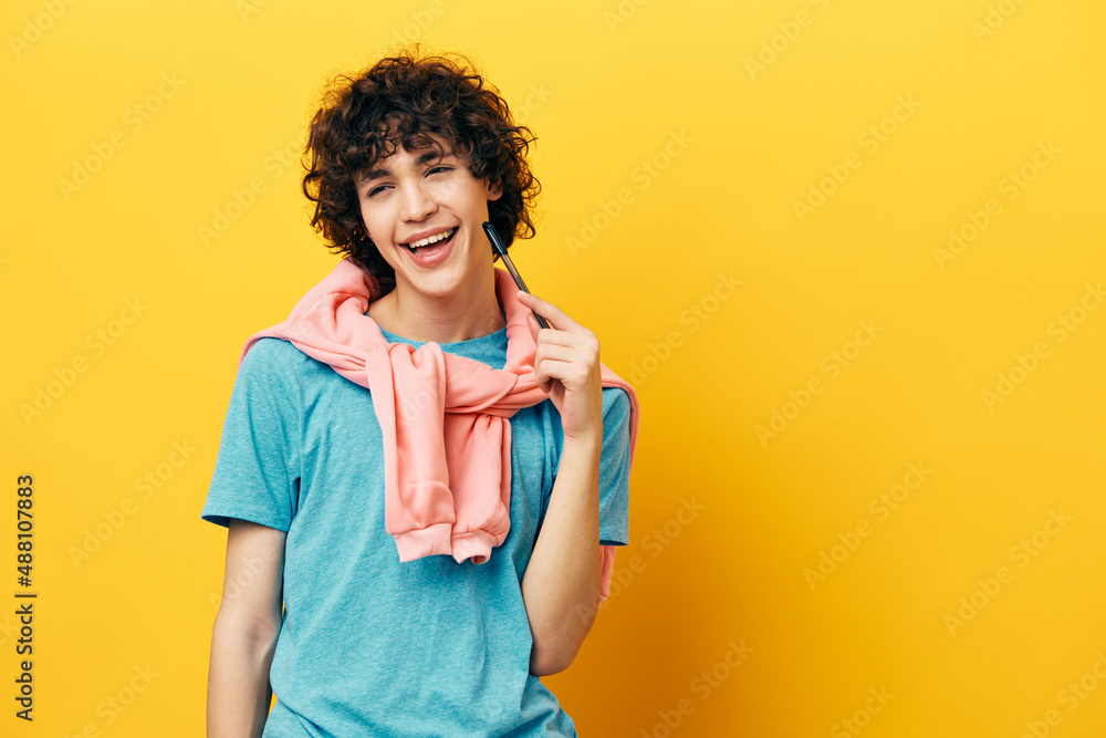 curly guy pen near the face college learning yellow background curly guy pen near the face college learning yellow background