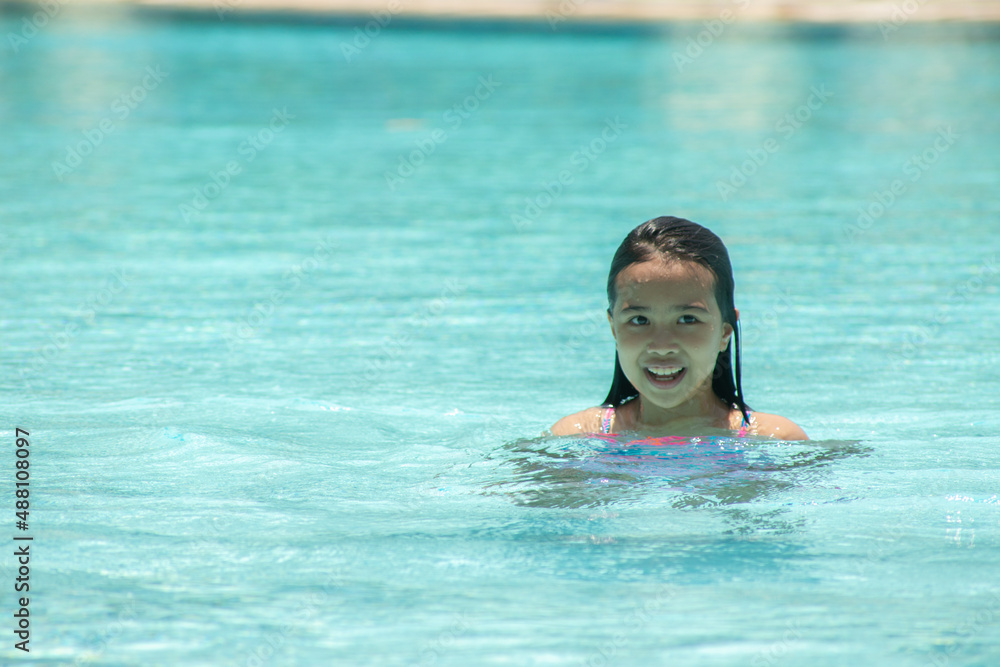 happy young girl swimming in the pool