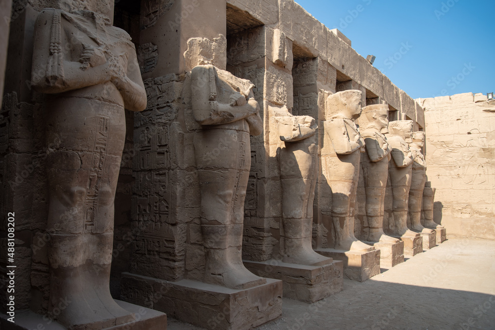Portico with osirical statues in the courtyard of the temple of Ramses III. Temple of Karnak in Luxor - ruined Thebes Egypt. Portico with osirical statues in the courtyard of the temple of Ramses III. Temple of Karnak in Luxor - ruined Thebes Egypt.