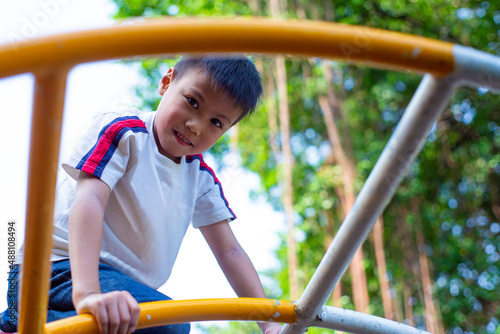 cute little boy playing on the playground and looking