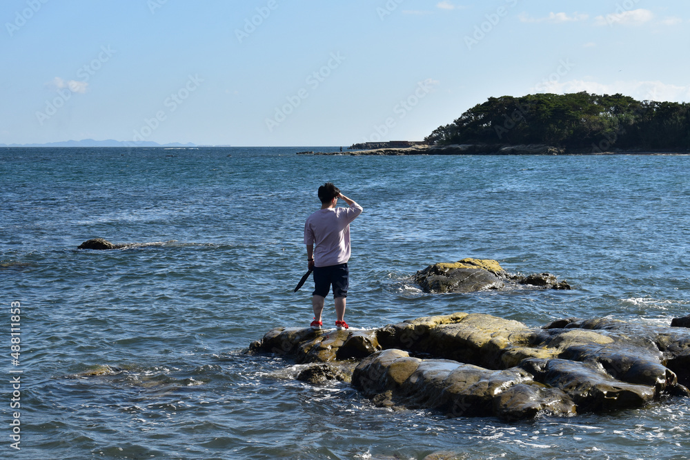 パラソルを持って岩の海を散歩するようになった男